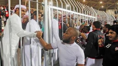 Ismail Matar celebrates with an Emirati supporter after the UAE secured their semi-final spot on Friday. Mohammed Dabbous / Reuters