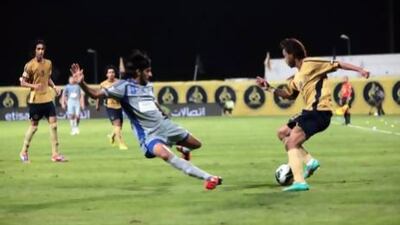 Humaid Abbas, No 8, trying to tackle Dubai's Waleed Khaleed, was one of four goal scorers for Al Nasr during their Etisalat Cup match tonight. Jeffrey E Biteng / The National