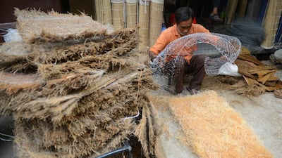 An Indian labourer prepares khus grass mats at the roadside in Amritsar for traditional desert coolers for Indian homes in the summer. AFP