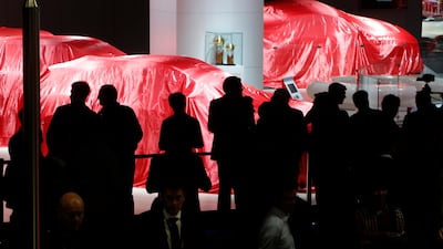 Visitors wait for Ferrari to reveal their latest models at Frankfurt. Michael Probst / AP Photo