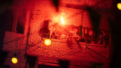 Revellers ignite flares as they gather for a mass iftar in the Matareya district of Cairo, Egypt. EPA