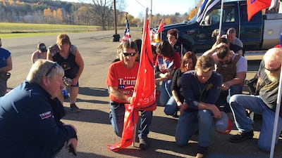 Supporters of the US president who still refuse to recognize Joe Biden's victory, including local Republican Candidate Doug McLinko (L) and Eamon Daley, 28, (2nd R), kneel as they pray outside Jones Diner in Towanda, Pennsylvania on November 8, 2020. They won't believe it "until the results are certified". AFP