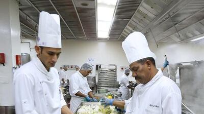 Cooks preparing food inside the kitchen at Dubai World Trade Centre in Dubai. Pawan Singh / The National