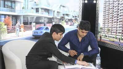 A Paradise group staff talks to a potential buyer at the Indian Property Show in Dubai. Sarah Dea / The National