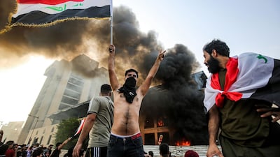 A masked protester flashes the victory sign in Baghdad's Tahrir Square. AFP