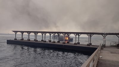 A boat burns off the scorched waterfront after wildfires fanned by the winds of a distant hurricane spread. Reuters