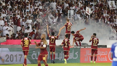 Al Wahda players celebrate in front of their fans after scoring the opening goal.