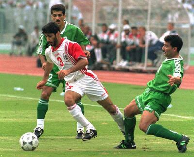 UAE's Munther Abdulla, centre, dribbles past Iraqi defenders Hayder Majeed, left, and Esam Salem during their Asian Cup quarter-final in Abu Dhabi. Jorge Ferrari / AFP