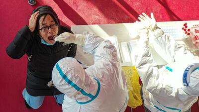 A health worker takes a swab sample from a resident, to be tested for the Covid-19 coronavirus at a temporary testing centre in Shenyang, in China's northeast Liaoning province. AFP