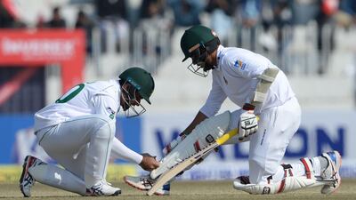 Pakistan's Abid Ali helps Bangladesh batsman Saif Hassan during the third day of the first Test. AFP