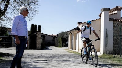 Davide Martinelli waves to his father Giuseppe as he leaves his home with his bike to deliver medicine to residents in Lodetto, near Brescia, Northern Italy. AP Photo