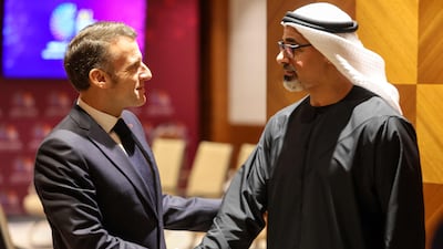 Sheikh Khaled bin Mohamed, Crown Prince of Abu Dhabi, greets French President Emmanuel Macron. AFP