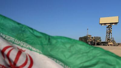 A handout photo made available by the Iranian Army office shows a national flag in front of an Iranian radar system system during the first day of the air defense exercise of 'Aseman Velayat 99', in an unidentified location in Iran. AFP