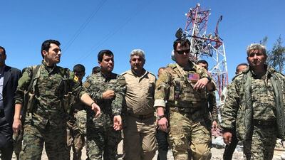 A US military commander, second from the right, is seen walking with Kurdish fighters from the People's Protection Units (YPG) at the group's headquarters, which was hit by Turkish air strikes in Mount Karachok near Malikiya, Syria on April 25, 2017. Rodi Said / Reuters