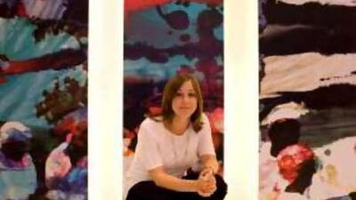 The artist Julia Ibinni poses for a portrait in front of her work at Abu Dhabi National Exhbition Center.