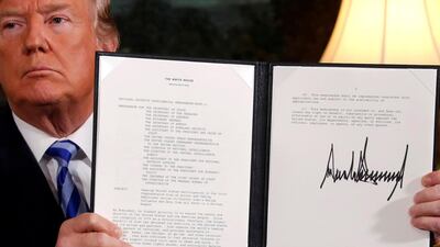 US President Donald Trump holds up a proclamation declaring his intention to withdraw from the Iran nuclear deal in 2018. Reuters