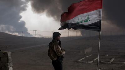 A fighter from a local tribe keeps watch from his rooftop outpost in Al Qayyarah, Iraq, on November 10, 2016, under smoke-filled skies from burning oil wells set ablaze by fleeing ISIL members. Many families have begun returning to their homes in the recently liberated towns south of Mosul. Chris McGrath / Getty Images