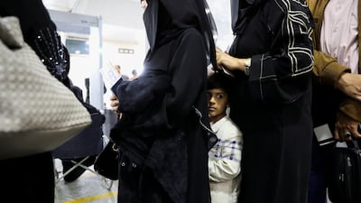 A boy stands with relatives in a line at the departures lounge to board the flight at Sanaa International Airport. Reuters