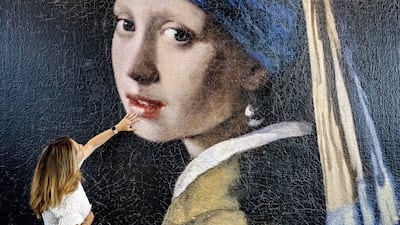 A woman touches the surface of an enlarged version of the famous painting 'Girl with a Pearl Earring' by Johannes Vermeer at the 'Mauritshuis' museum in The Hague, The Netherlands, 08 June 2023. The Vermeer painting has been enlarged a 100-times as a 3D print to become a four-meters high plastic colossus which is exhibited in the foyer of the museum. The giant 3D print clearly shows how the canvas has developed over the years and which painting techniques have been used. EPA / ROBIN UTRECHT