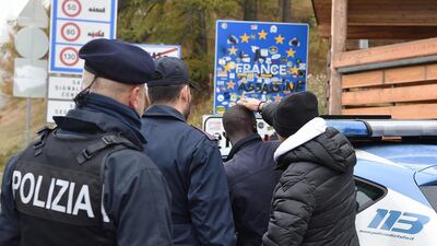 French and Italian policeman check migrants at the border between Italy and France, in Claviere, Italy. EPA