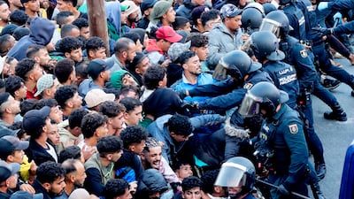 A group of migrants living on Benitez Beach wait to be transferred by Civil Guard members to a newly built pavilion in Ceuta, Spain. EPA