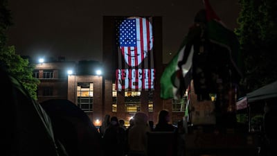 Student protesters project an image of US President Joe Biden with the words 'Genocide Joe' on an American flag at George Washington University. AFP
