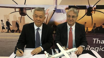 Anawat Leelawatwatana, senior vice-president for finance and accounting at Bangkok Airways, and ATR's Chief executive Christian Scherer, sign the deal in Singapore. /Brenda Goh/Reuters