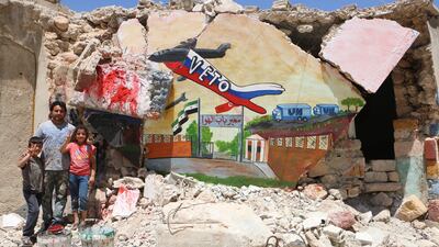 Artist Aziz Al Asmar poses with children next to his mural in Bennesh.