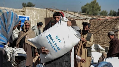 On October 19, 2021 Afghans carry sacks of grains distributed as aid by the World Food Programme in Kandahar, Afghanistan. AFP