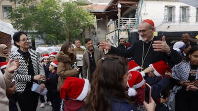 TOPSHOT - Cardinal Pierbattista Pizzaballa (2nd R), Latin Patriarch of Jerusalem, greets children during a pastoral visit to the Holy Family Parish in Gaza City on December 19, 2025. Jerusalem's Latin Patriarch, Cardinal Pierbattista Pizzaballa, arrived in Gaza on December 19 for Christmas Mass at the Holy Family Parish in Gaza City, which hosts the Palestinian territory's only Roman Catholic church. (Photo by Omar AL-QATTAA / AFP)