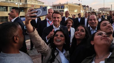 French President Emmanuel Macron and his Egyptian counterpart Abdel Fattah El Sisi pose for selfies with members of the public, near the Citadel of Qaitbay in Alexandria. AFP