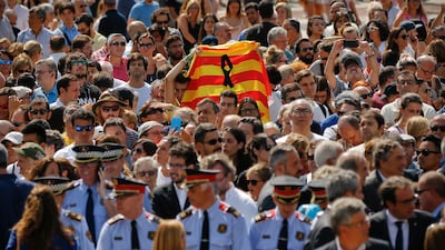 People hold up a Catalan flag at a minute's silence in Barcelona for the terrorist attack victims in Las Ramblas, Barcelona. World leaders condemned the attack. Francisco Seco / AP Photo