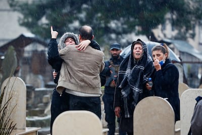 Relatives mourn during the funeral of victims of the attack in Homs. AP