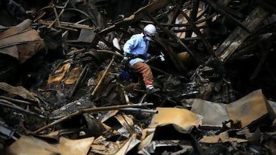 A Japanese fireman searches for bodies in Minamisanriku, Myagi province, yesterday, 10 days after the massive earthquake and tsunami that ravaged northeastern Japan.