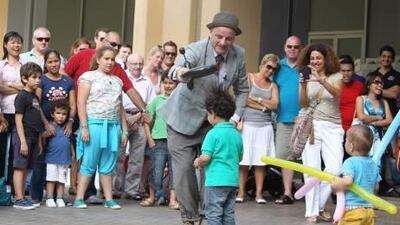 Herbie Treehead from the UK performs with Ali Ghaleb, 2 years old, at the Dubai Marina Street Festival in Dubai.