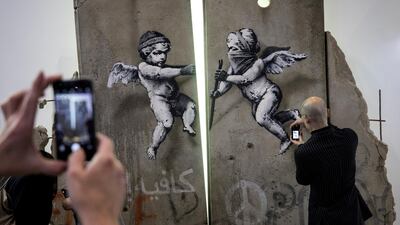 Visitors take photographs of the 'replica separation barrier'. Reuters