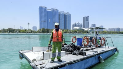 Dive volunteers with the collected bags of trash at Abu Dhabi Dhow Harbour. Victor Besa / The National