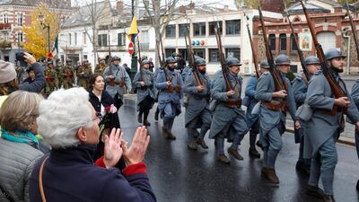 A local resident applauds as history enthusiasts dressed as French soldiers parade during a commemoration ceremony in Epernay, France. Reuters