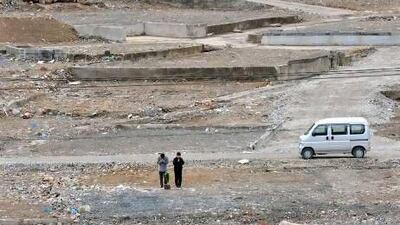 A couple on Sunday pray where their home was standing before last year's earthquake and tsunami. They were participating in the first-year anniversary observation of the disaster in Onagawa, Miyagi prefecture. Public life in Japan paused yesterday as the nation marked a year since more than 19,000 people were killed.