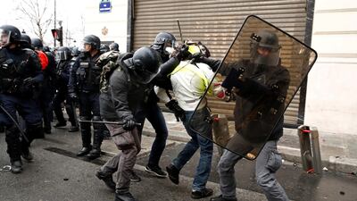 French police apprehend a protester wearing a yellow vest during clashes with police during a national day of protest by the 'yellow vests' movement in Paris, France. Reuters