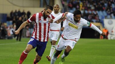 Atletico Madrid midfielder Arda Turan, left, vies with Granada defender Brayan Angulo during their La Liga match on Wednesday. Pedro Armestre / AFP / March 26, 2014