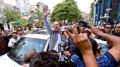 Former Prime Minister and leader of the Pakistan Muslim League, Nawaz Sharif, center, waves to his supporters as he leaves a polling station after casting his vote in Lahore, Pakistan, Saturday, May 11, 2013. Defying the danger of militant attacks, Pakistanis streamed to the polls Saturday for a historic vote pitting a former cricket star against a two-time prime minister and an unpopular incumbent. But attacks that killed several people and wounded dozens more underlined the risks many people took just casting their ballots. (AP Photo/Anjum Naveed) *** Local Caption *** Pakistan Election .JPEG-0ed8e.jpg