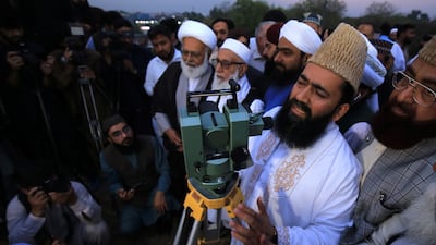 The chairman of a moon-sighting committee points a telescope at the skies in Peshawar, Pakistan. EPA