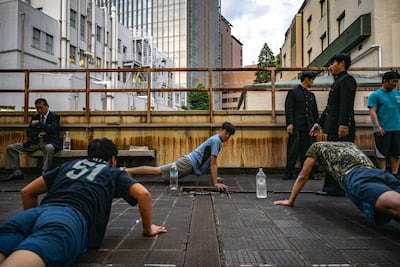 Members of the Meiji University 'oendan' cheering group work out before hand-clapping practice on campus in Tokyo. AFP