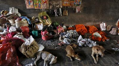 Female vendors selling flower garlands eat their lunch under a bridge at a wholesale flower market.