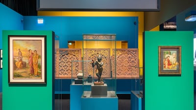 A 19th-century statuette of Krishna sits alongside works by Raja Ravi Varma at Louvre Abu Dhabi's Bollywood Superstars exhibition. Photo: Louvre Abu Dhabi