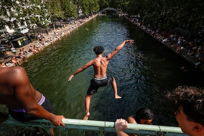 A young man jumps from a bridge to cool off in the Canal Saint-Martin, in Paris, France. An intense heatwave is gripped Western and Central Europe, pushing temperatures far above seasonal norms for mid-June. EPA