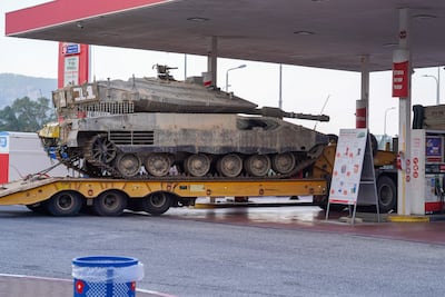 A lorrie carrying a tank stops at a gas station near the border between Israel and Lebanon. Willy Lowry / The National