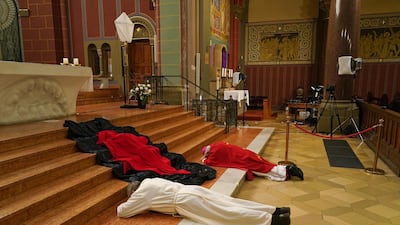 Berlin Archbishop Heiner Koch and Monsignor Hansjoerg Guenther prostrate themselves while rehearsing the veneration of the cross for the Good Friday liturgy that will be broadcast live from Saint Joseph Church. Getty Images