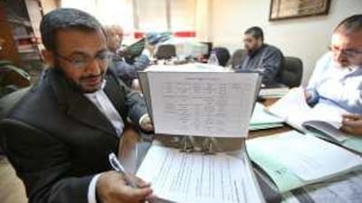 Badi Rafayaa, left, the head of the professional associations' anti-normalisation committee, checks papers during a meeting in Amman.